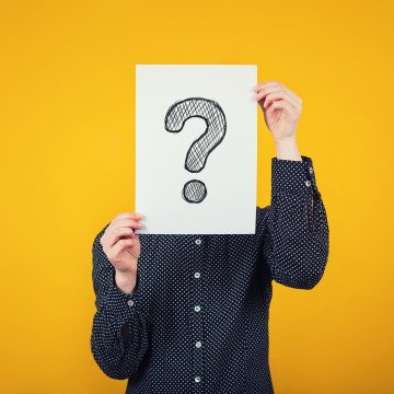 autopom extended car warranty service man in dark shirt holding question mark sign yellow orange background